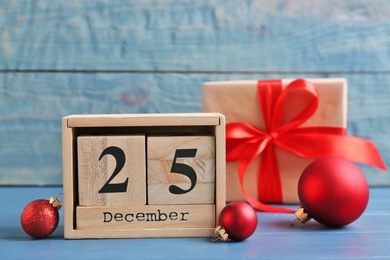 Photo of Wooden block calendar, gift box and decor on table. Christmas countdown