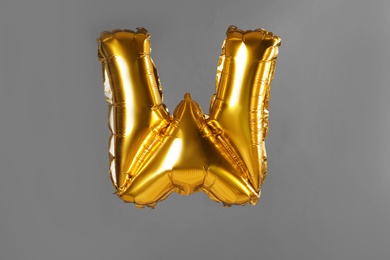 Photo of Golden letter W balloon on grey background