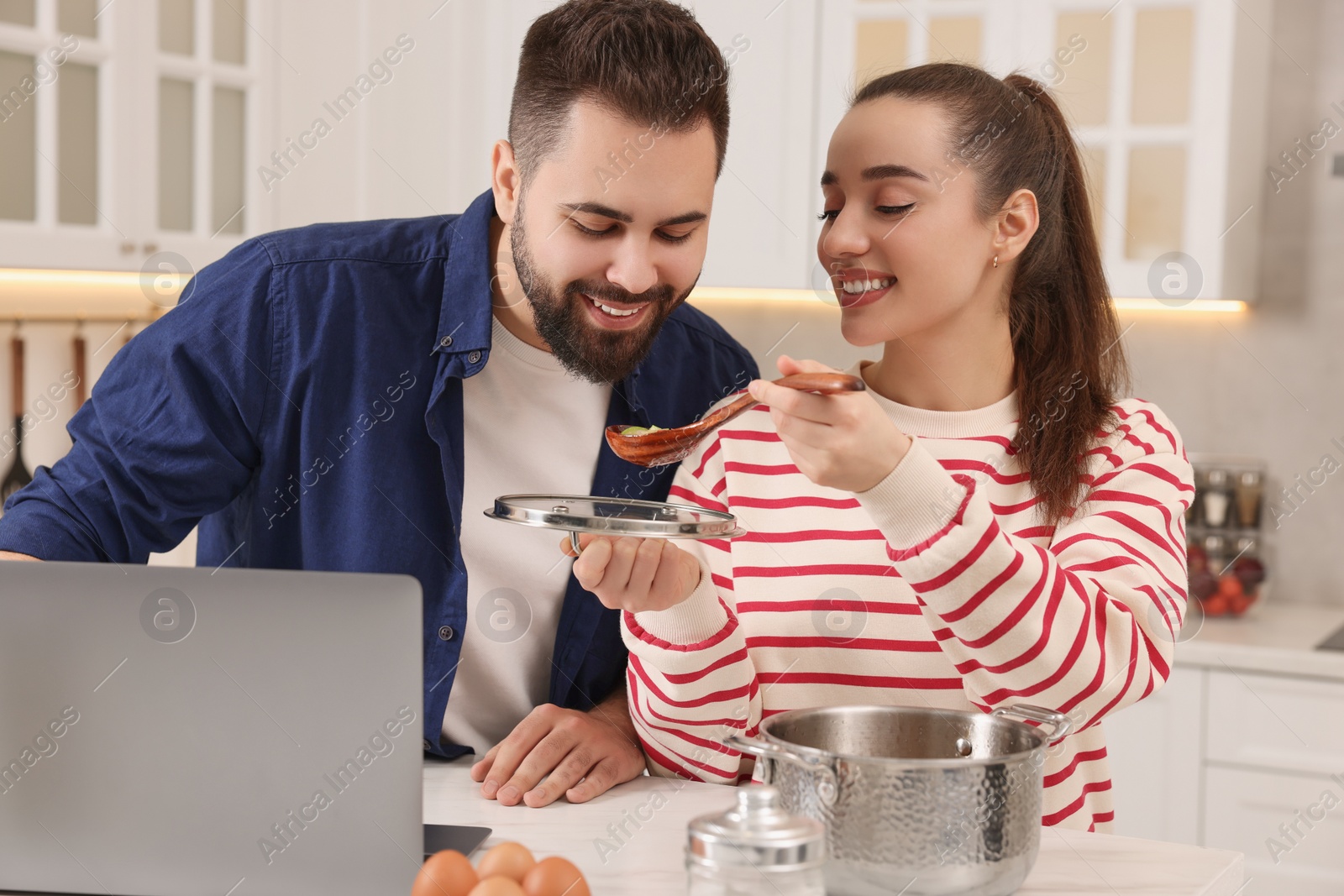 Photo of Happy lovely couple cooking together in kitchen