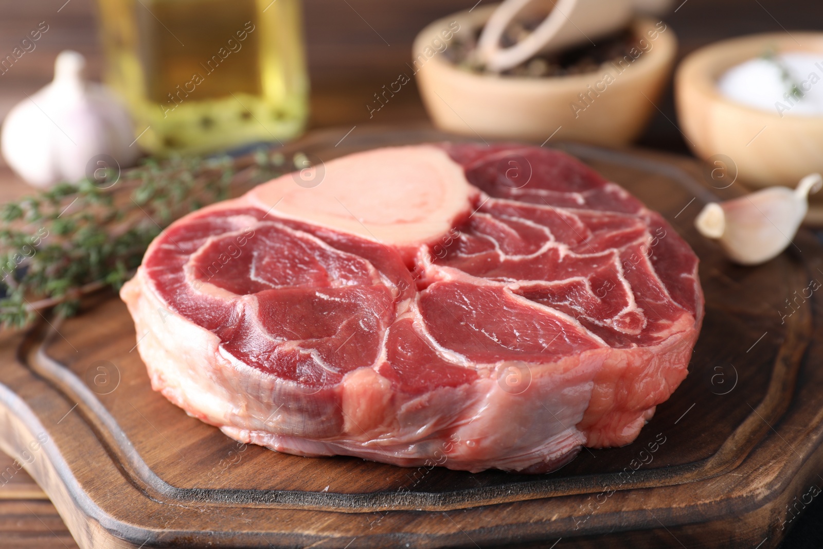 Photo of Piece of raw beef meat on wooden board, closeup