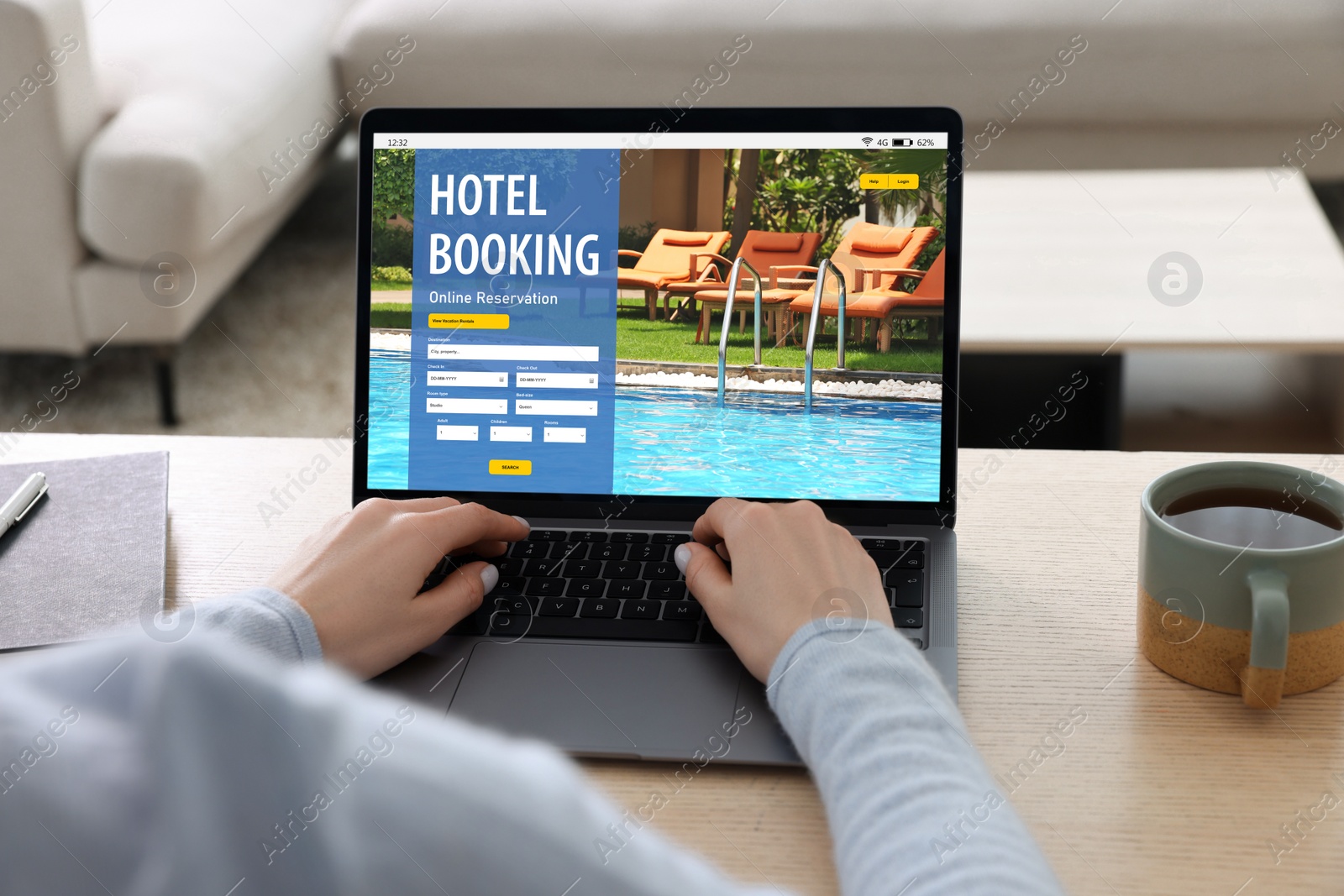 Image of Woman using laptop to book hotel at wooden table, closeup