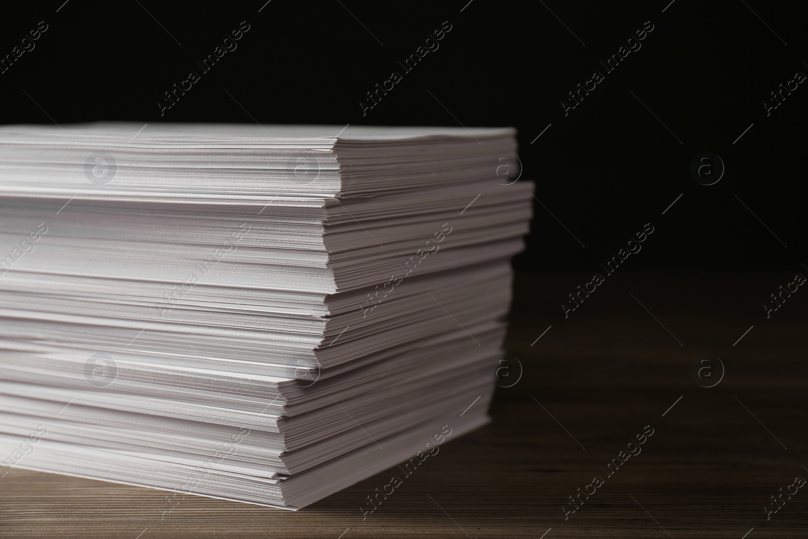 Photo of Stack of paper sheets on wooden table, closeup. Space for text