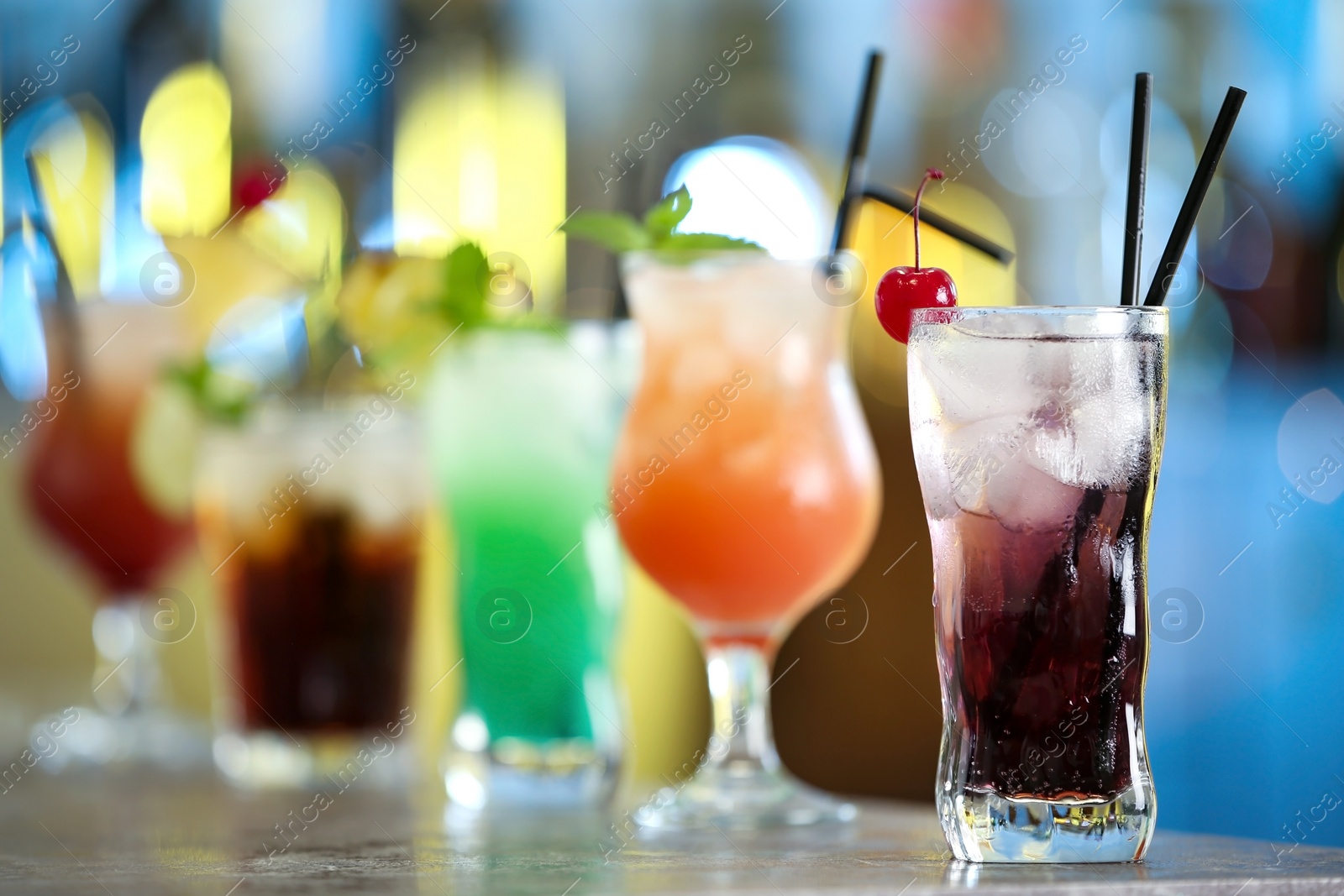 Photo of Row of different fresh alcoholic cocktails on bar counter