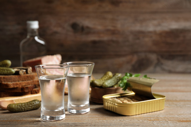 Photo of Cold Russian vodka with snacks on wooden table