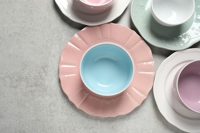 Beautiful ceramic dishware on light grey table, flat lay. Space for text