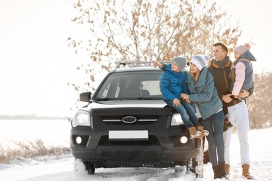 Happy family near car on winter day