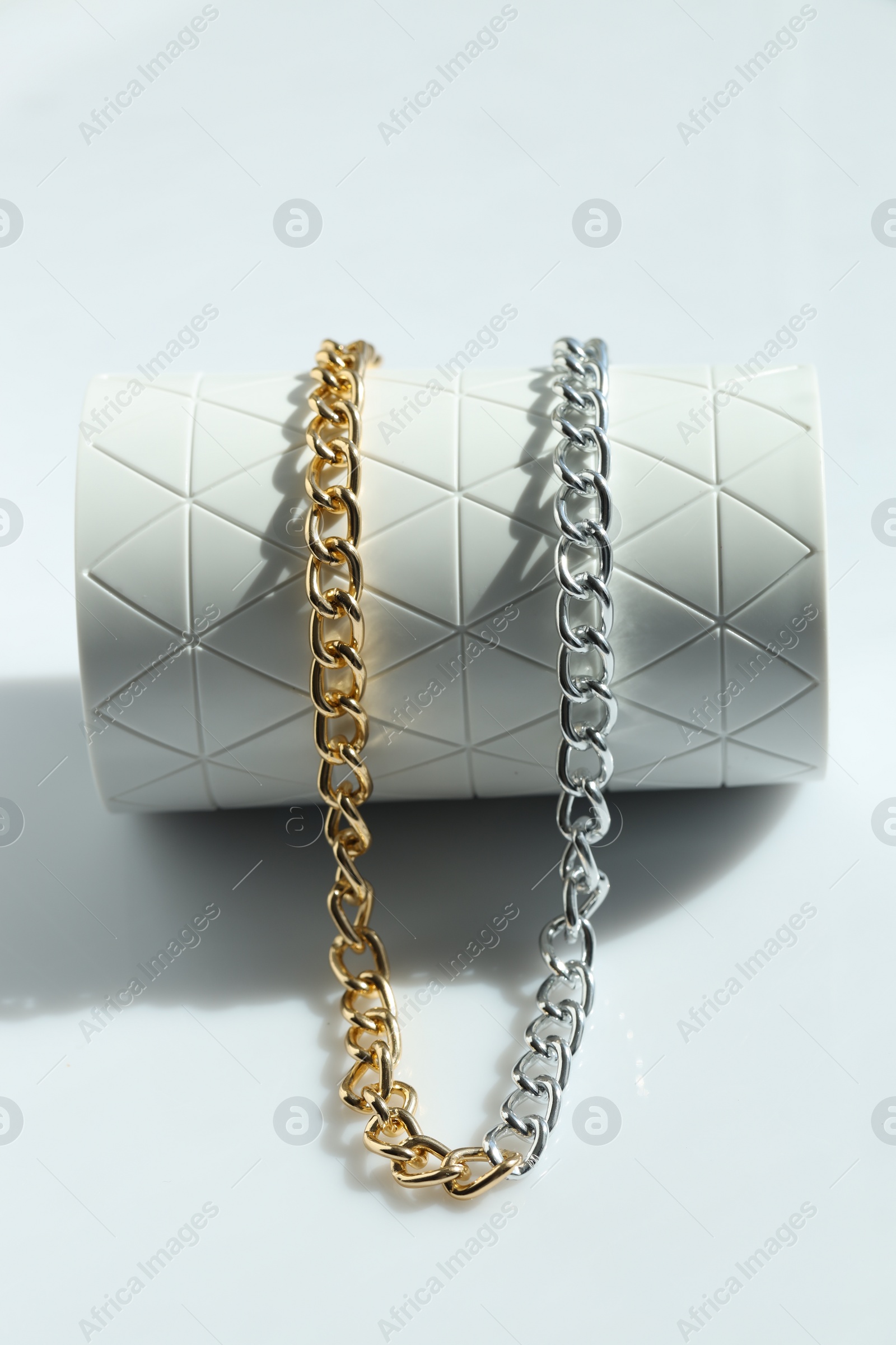 Photo of Metal chain on white table. Luxury jewelry