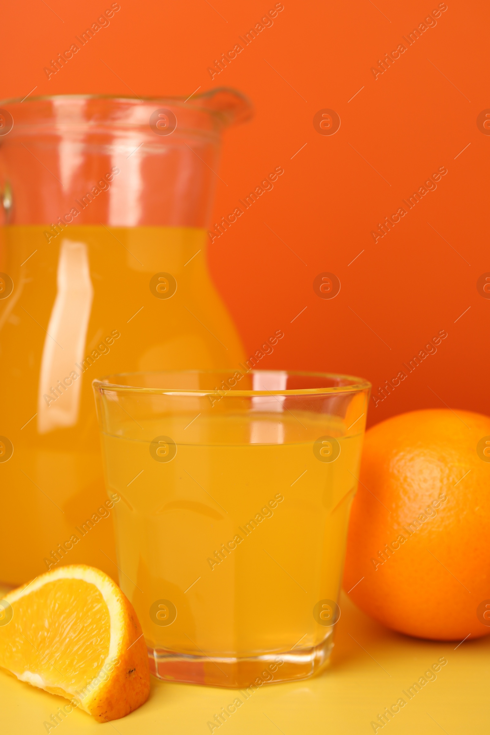 Photo of Orange juice and fruit on yellow table, closeup