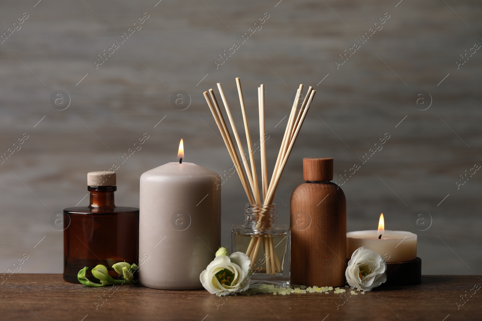 Photo of Beautiful composition with burning candles and different spa products on wooden table