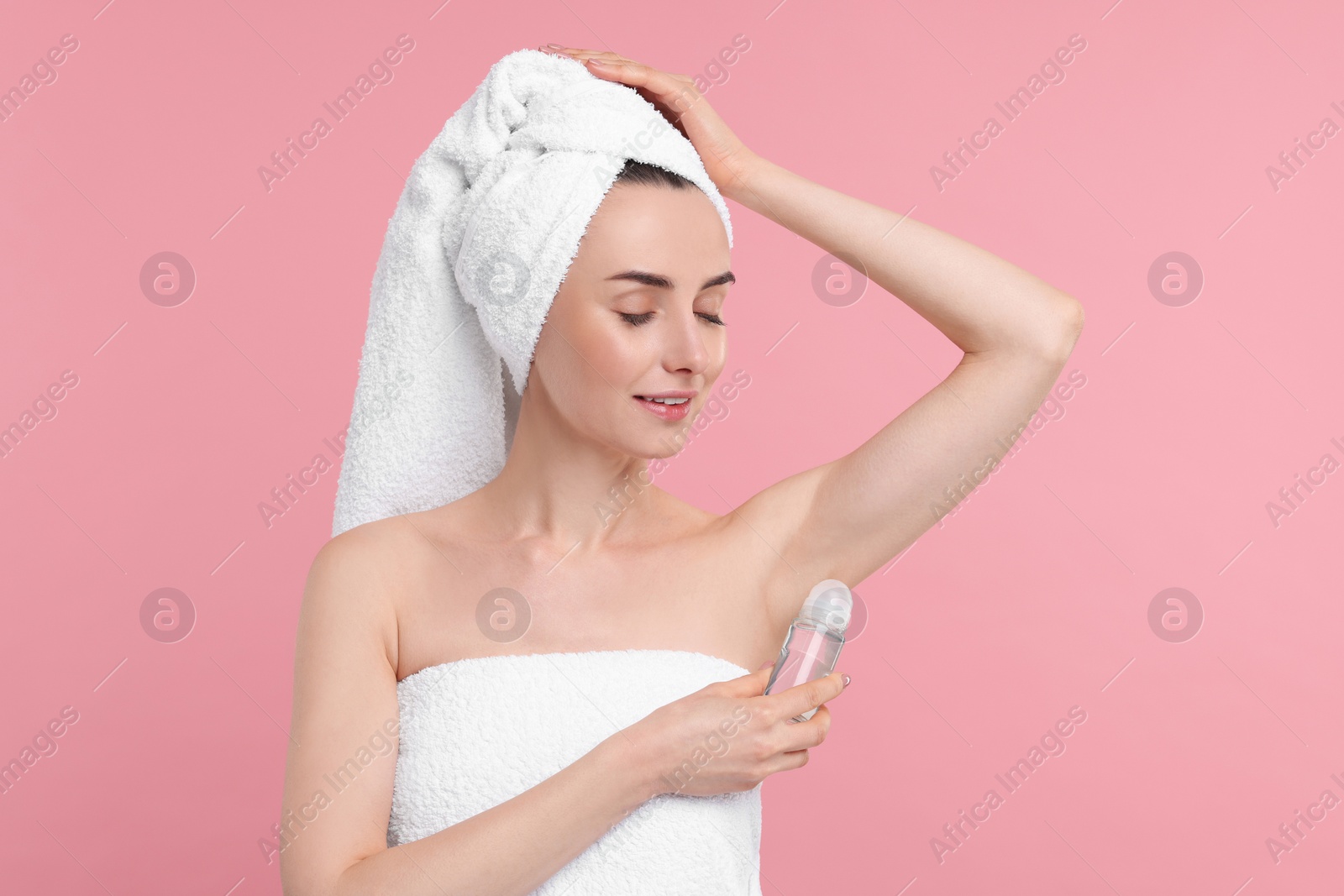 Photo of Beautiful woman applying deodorant on pink background