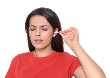 Photo of Young woman cleaning ear with cotton swab on white background
