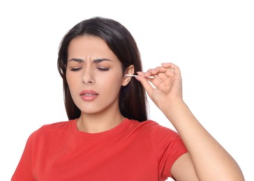 Young woman cleaning ear with cotton swab on white background