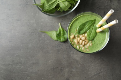 Flat lay composition with fresh green healthy spinach smoothie on grey table, space for text