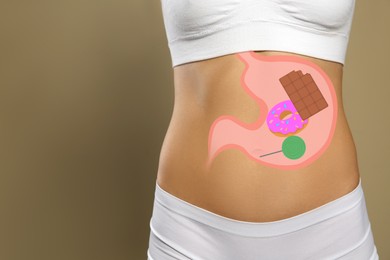 Woman with image of stomach full of junk food drawn on her belly against beige background, closeup. Unhealthy eating habits