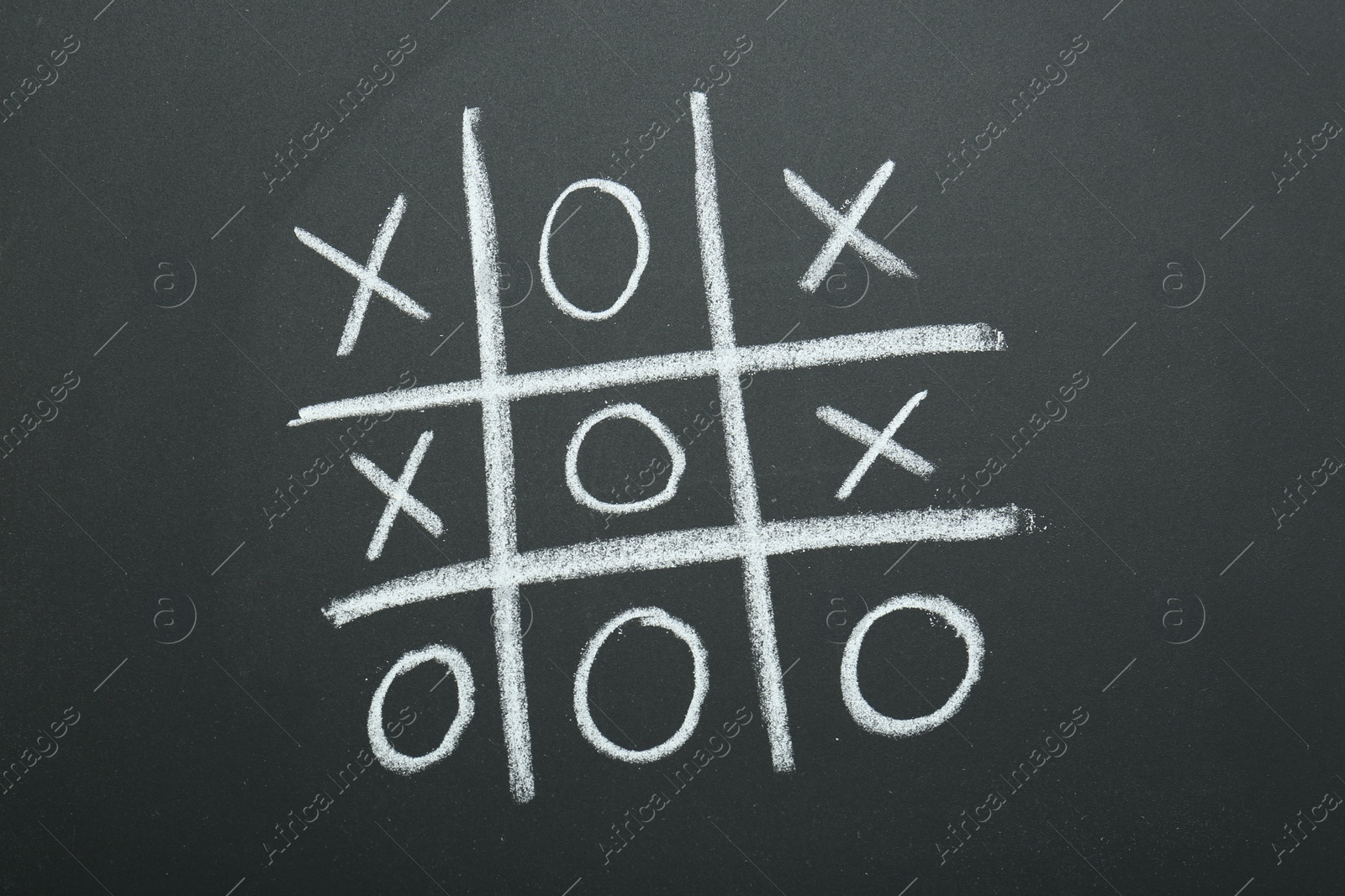Photo of Tic tac toe game chalked on blackboard