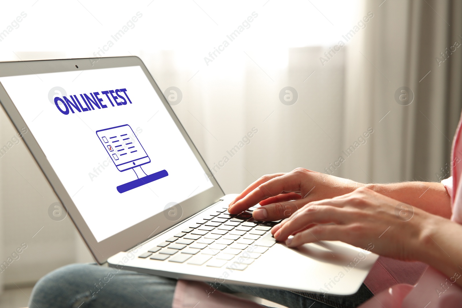 Image of Woman using laptop for online test indoors, closeup