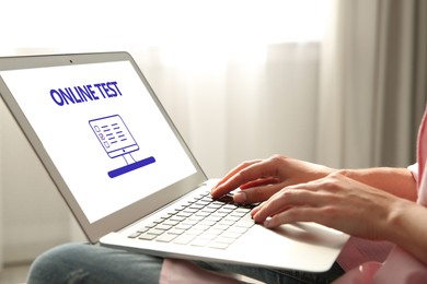 Image of Woman using laptop for online test indoors, closeup