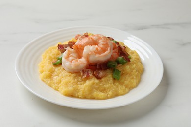 Photo of Plate with fresh tasty shrimps, bacon, grits and green onion on white marble table