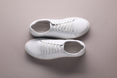 Pair of stylish white sneakers on grey background, top view