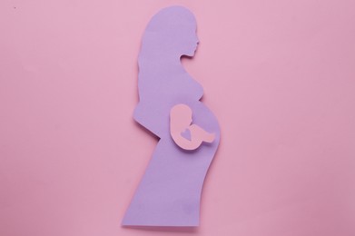 Photo of Woman`s health. Pregnant woman with baby on pale pink background, top view