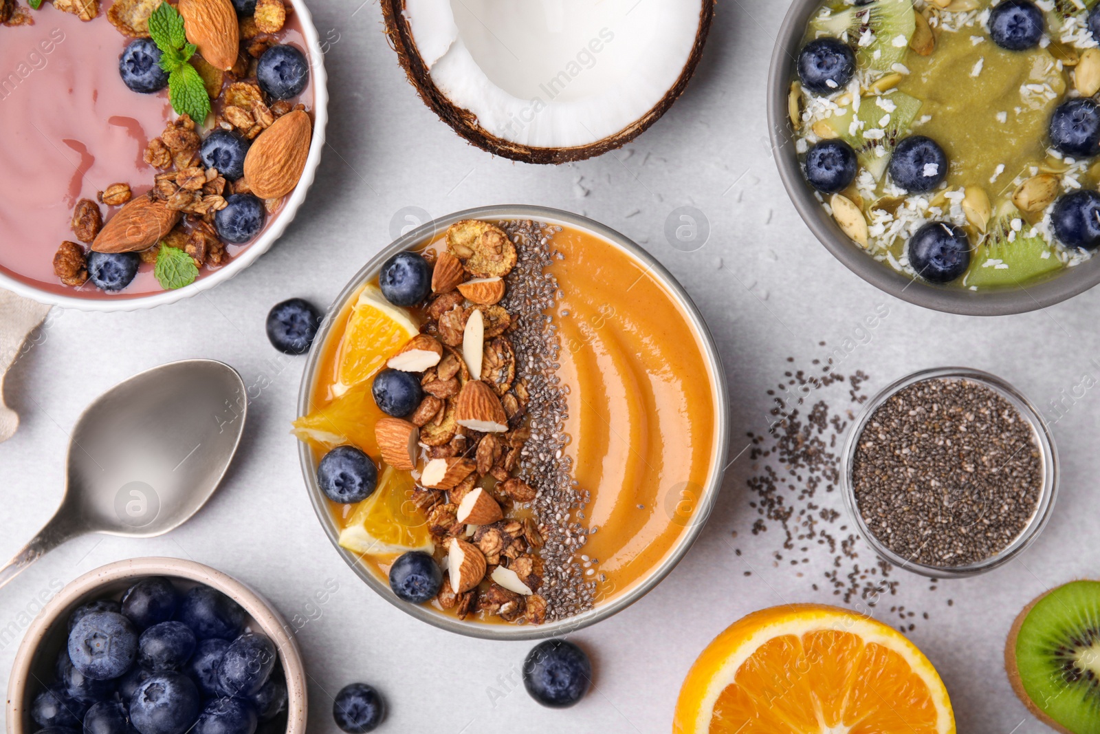 Photo of Bowls with different delicious smoothies and fresh ingredients on white table, flat lay