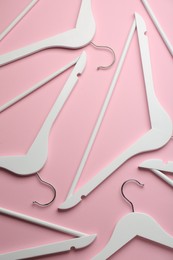 Photo of White hangers on pink background, flat lay