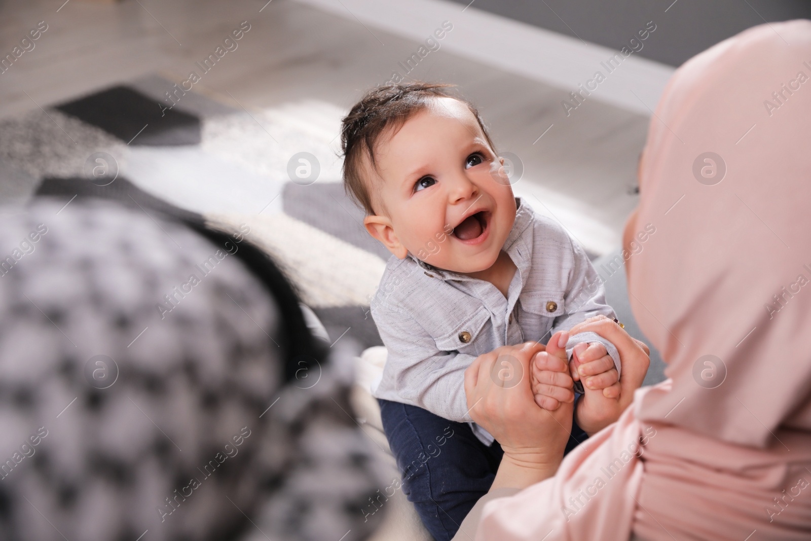 Photo of Happy Muslim family with little son at home