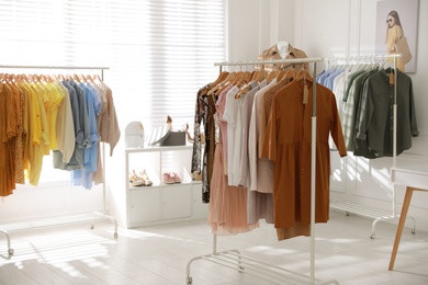 Photo of Stylish women's clothes and accessories in modern boutique