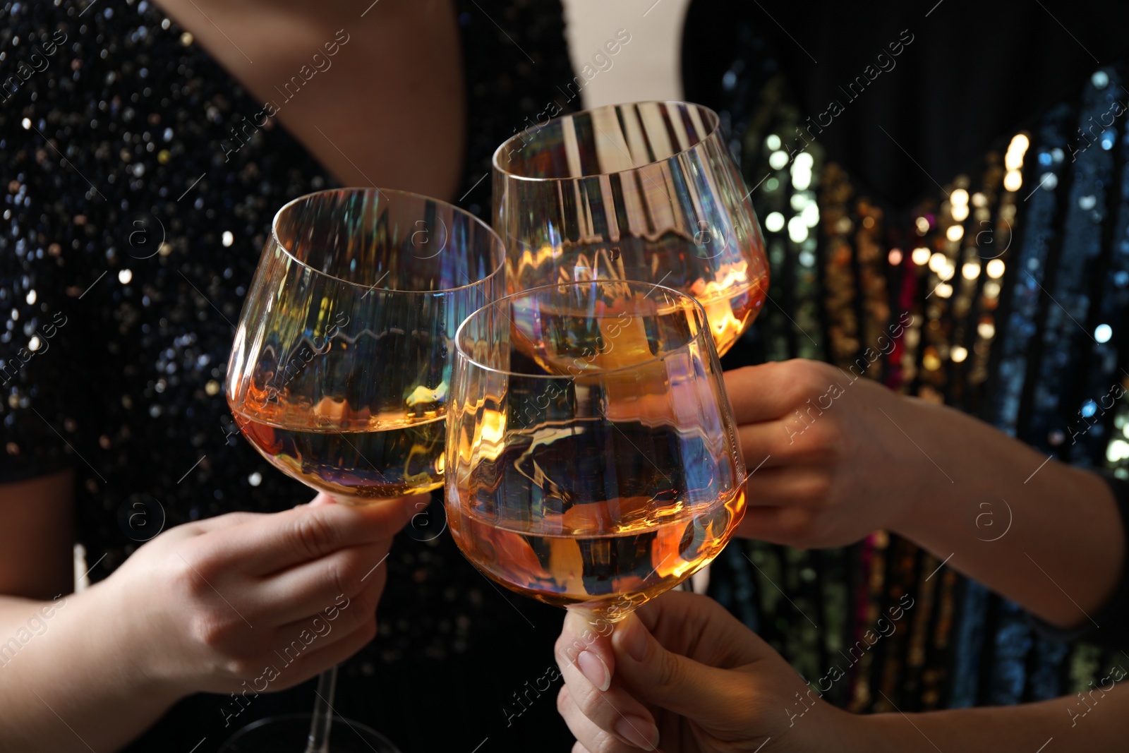 Photo of Women clinking glasses with white wine, closeup