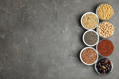 Photo of Different grains, seeds and space for text on grey table, flat lay. Veggie diet