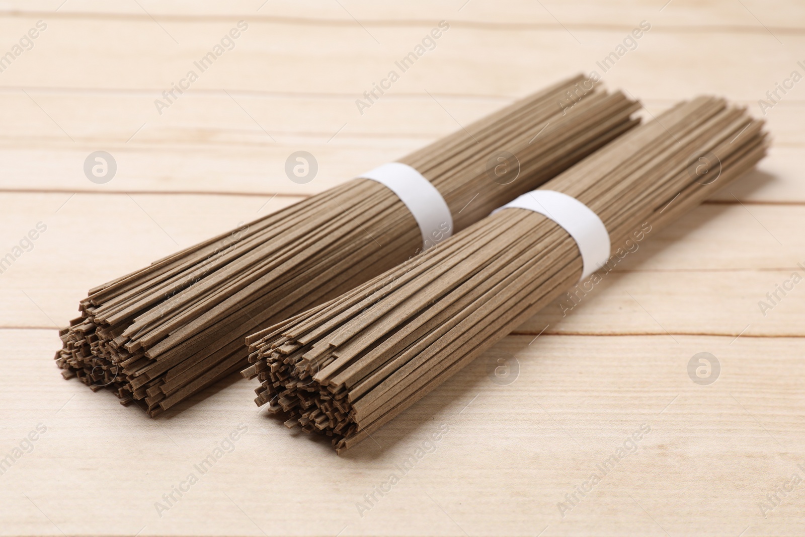 Photo of Uncooked buckwheat noodles (soba) on light wooden table