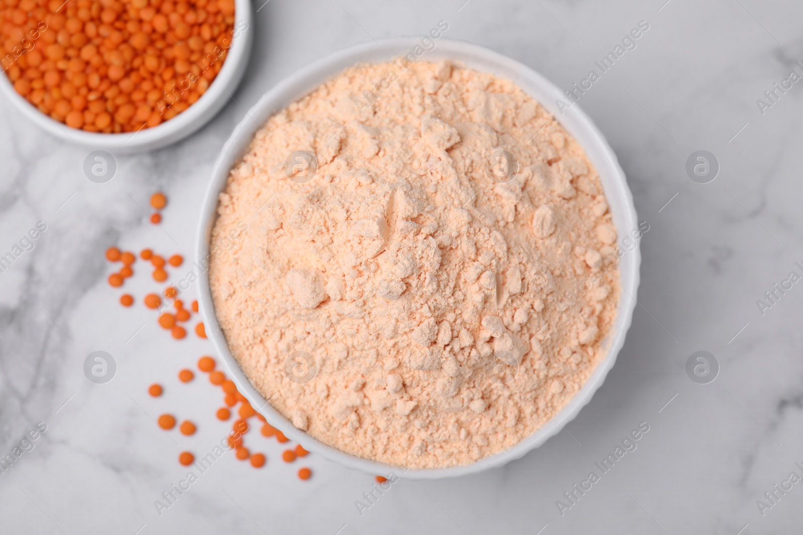 Photo of Lentil flour and seeds on white marble table, flat lay