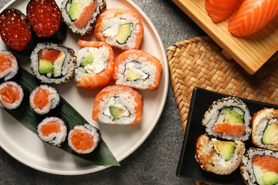 Photo of Flat lay composition with delicious sushi rolls on dark grey table