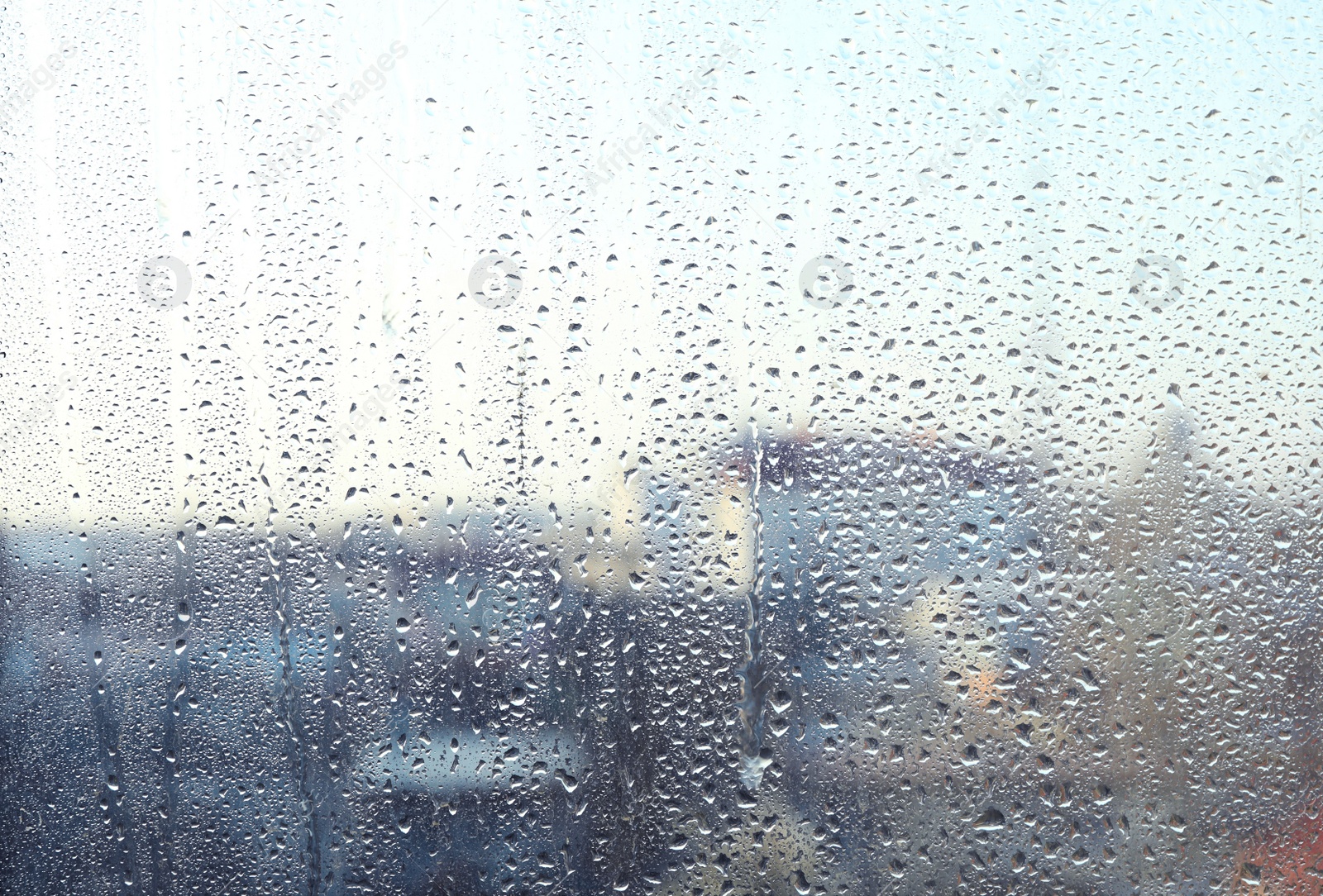 Photo of Blurred view of city from window on rainy day