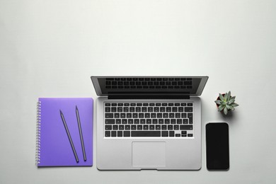 Flat lay composition with laptop and smartphone on light background. Space for text