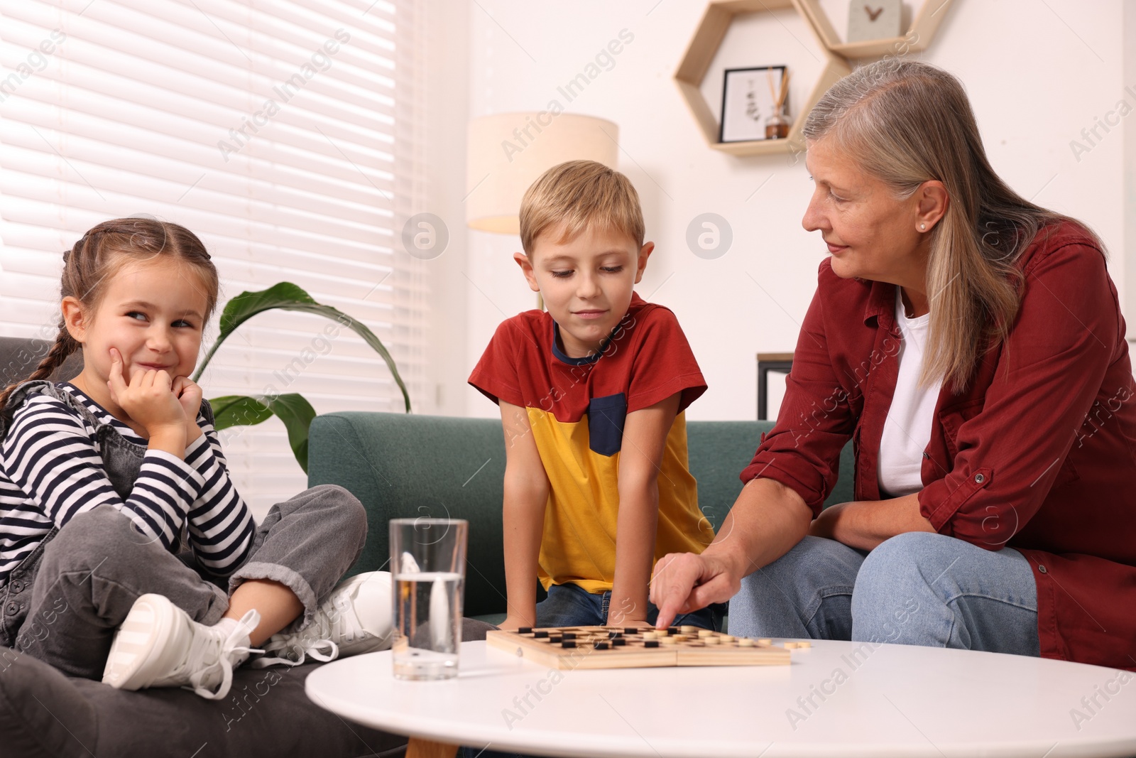 Photo of Family playing checkers at coffee table in room