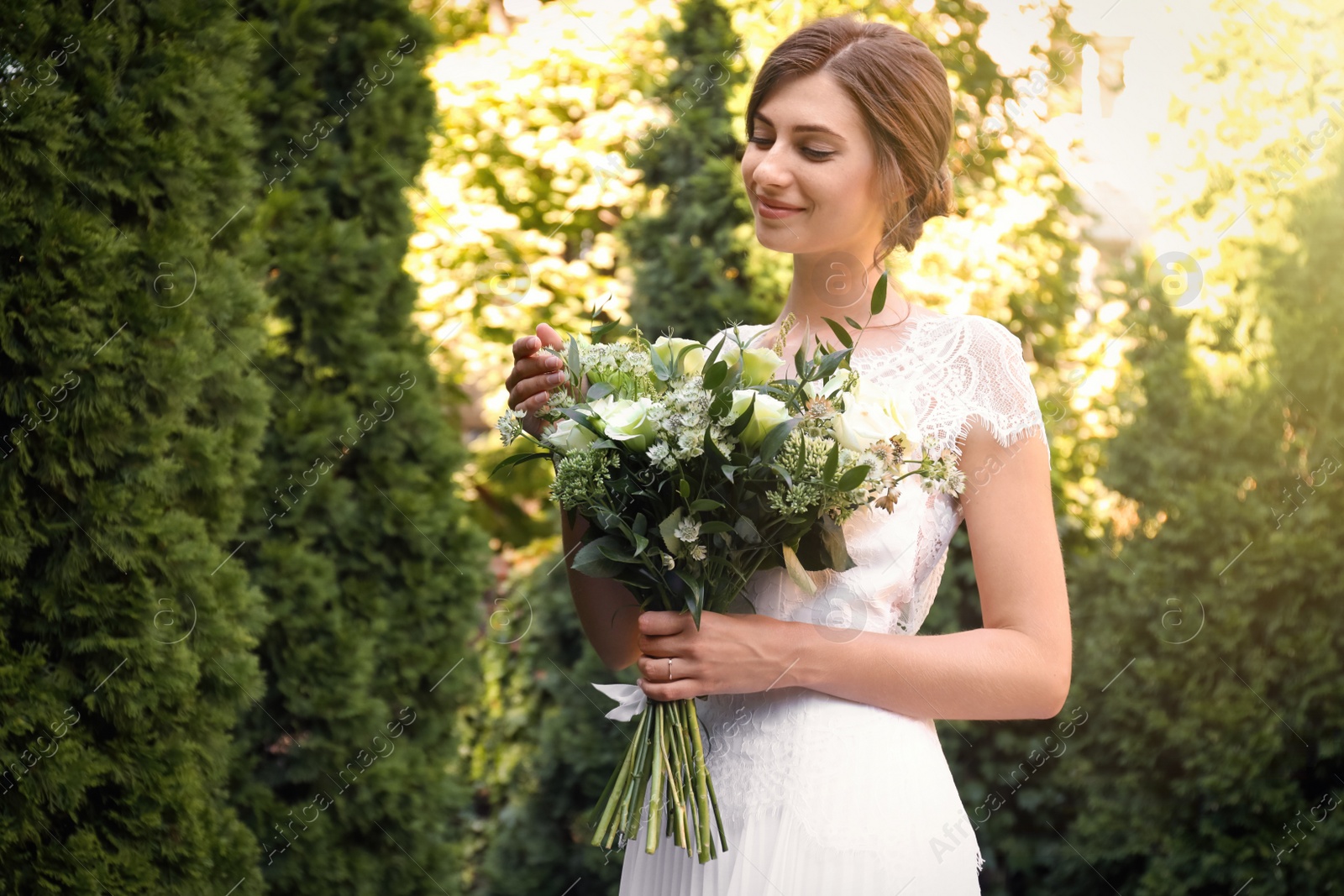 Photo of Gorgeous bride in beautiful wedding dress with bouquet outdoors