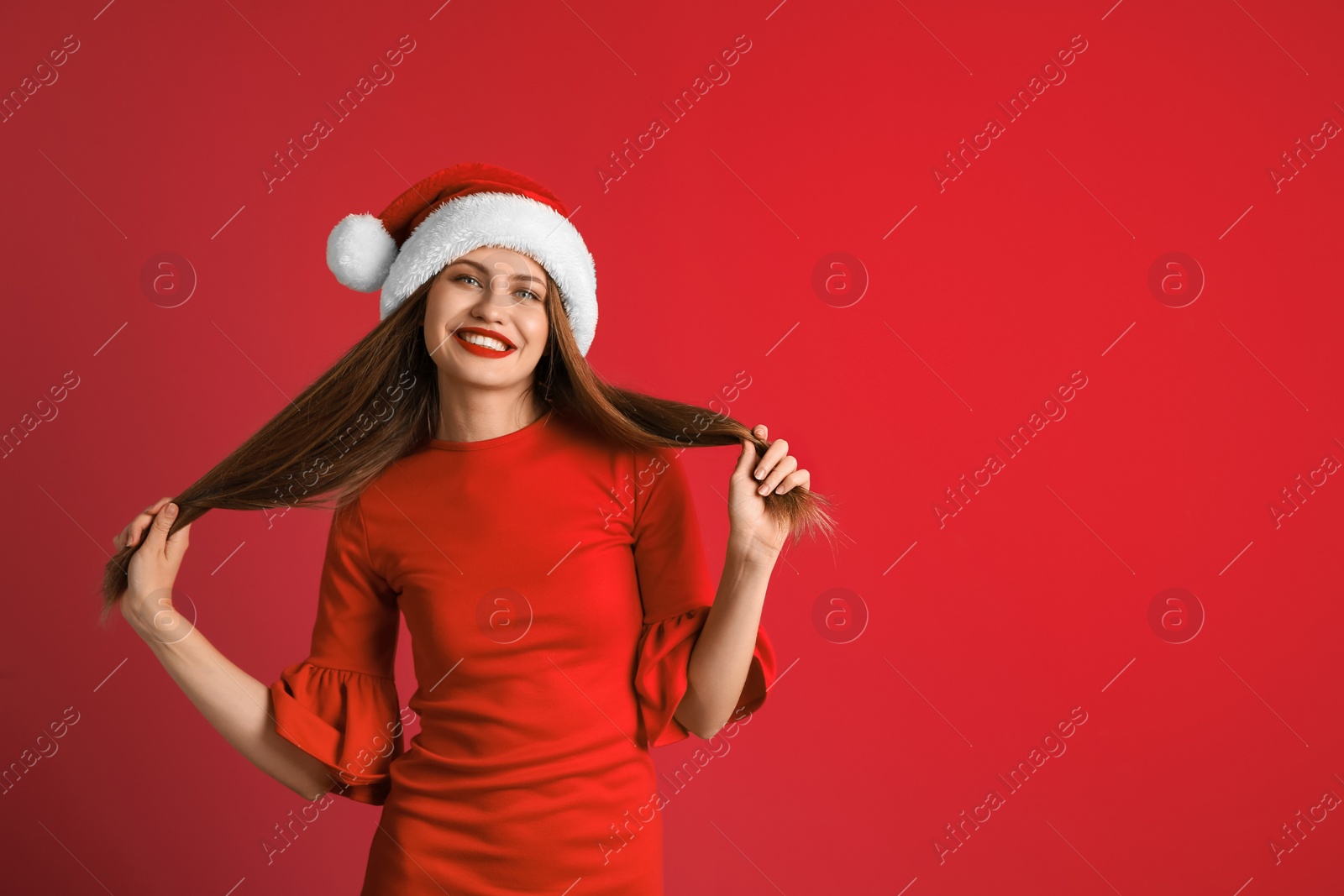 Photo of Young beautiful woman in Santa hat on color background. Christmas celebration