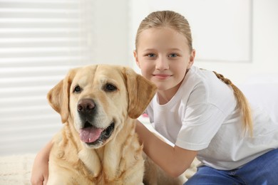 Photo of Cute child with her Labrador Retriever at home. Adorable pet