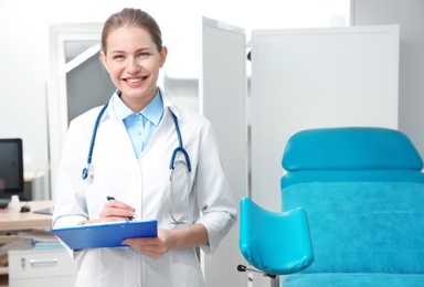 Photo of Portrait of young gynecologist with clipboard at workplace