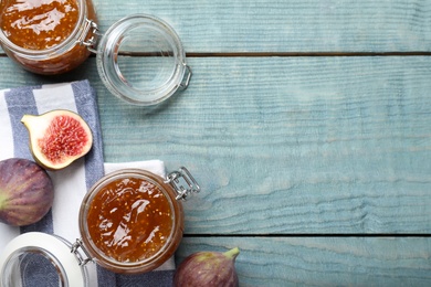 Photo of Flat lay composition with homemade delicious fig jam on blue wooden table. Space for text