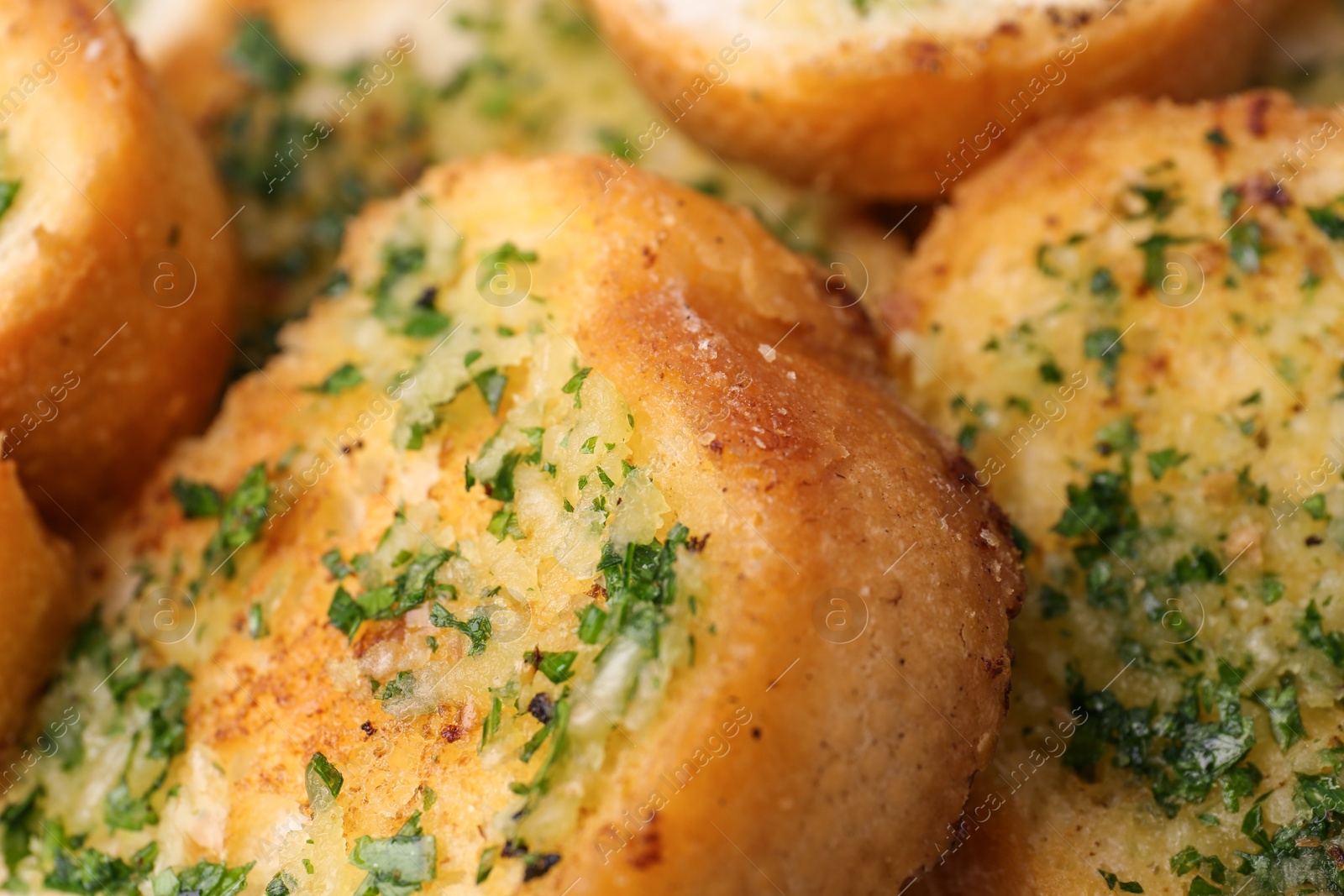 Photo of Slices of toasted bread with garlic and herbs as background, closeup