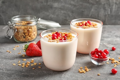 Photo of Glasses with yogurt, berries and granola on table
