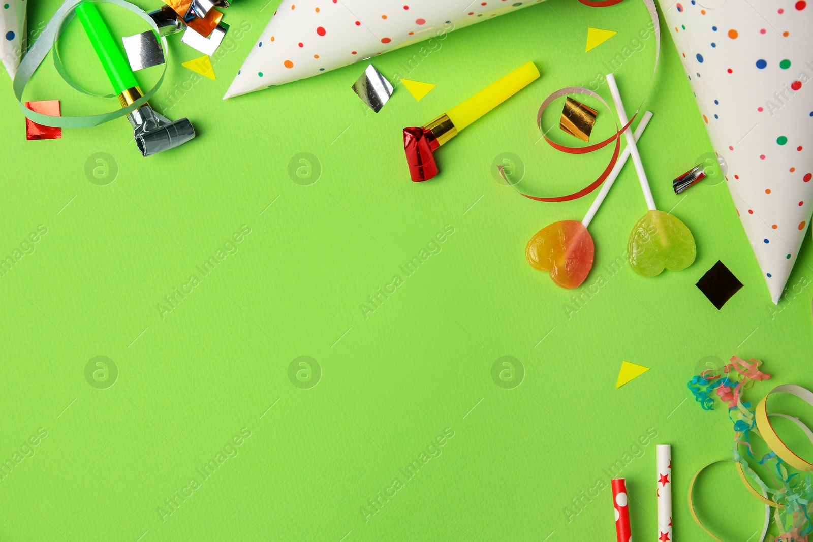 Photo of Colorful blowers, streamers and other festive decor on light green background, flat lay. Space for text
