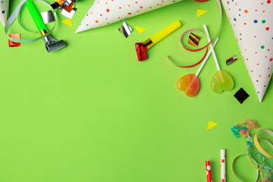 Colorful blowers, streamers and other festive decor on light green background, flat lay. Space for text