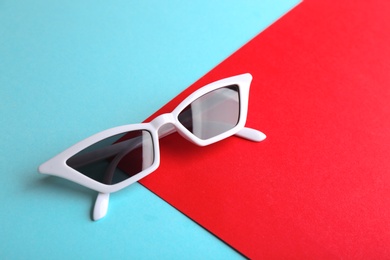 Stylish sunglasses on color background, above view with space for text. Summer time