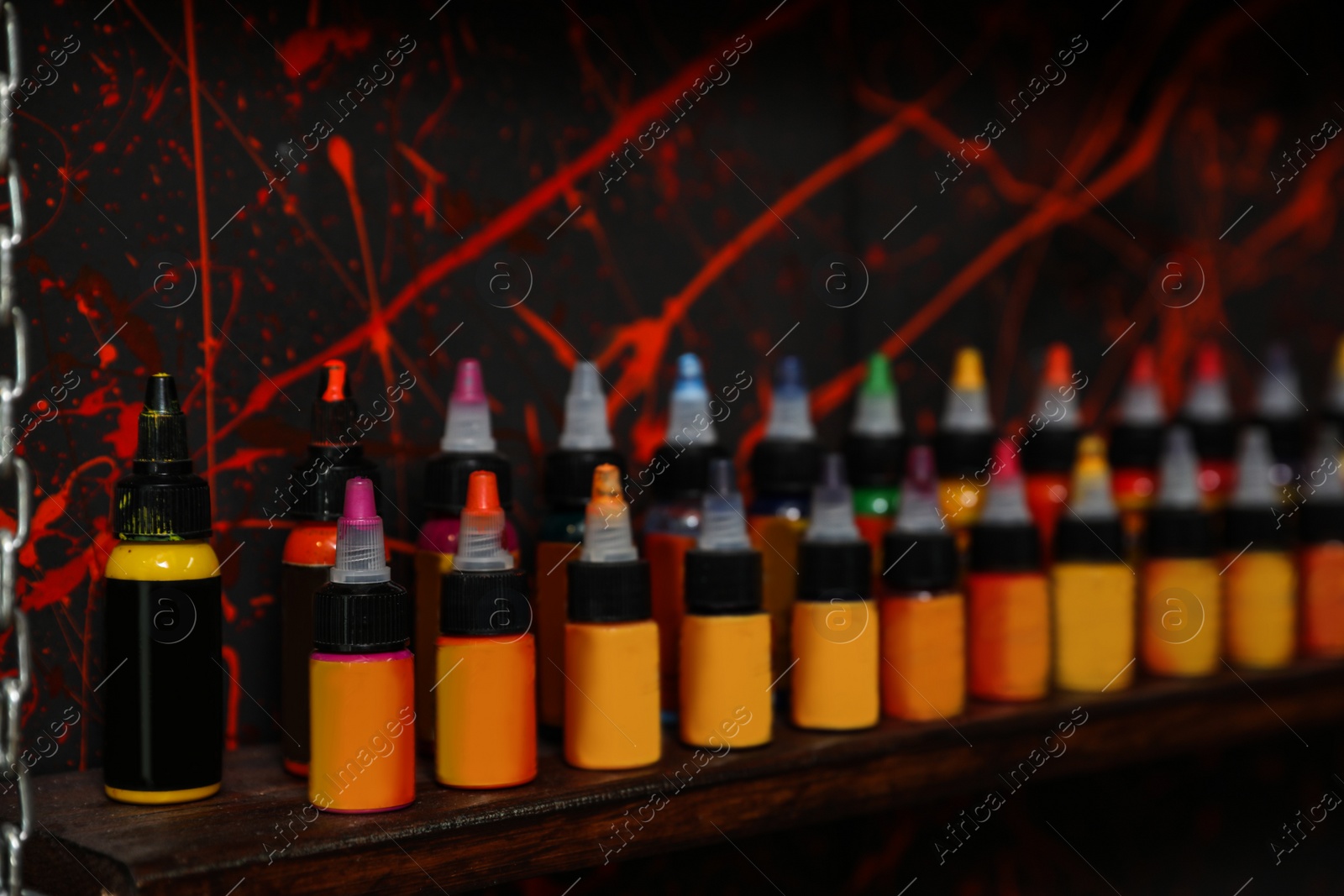 Photo of Bottles of inks on shelf in tattoo salon