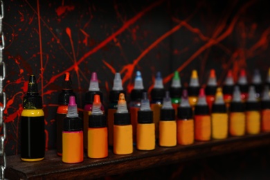 Photo of Bottles of inks on shelf in tattoo salon