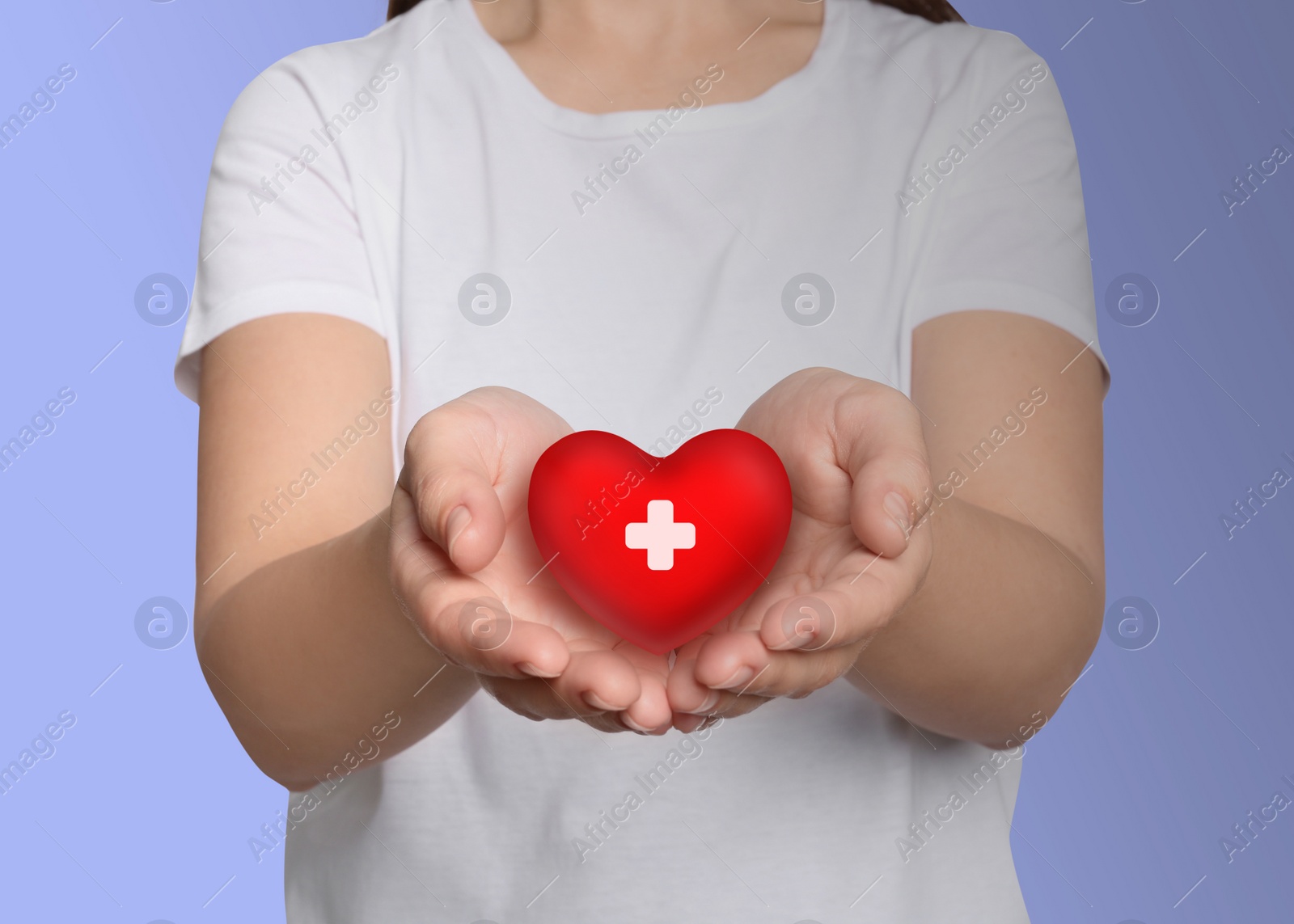 Image of Woman holding red heart in hands on light background, closeup. Blood donation concept