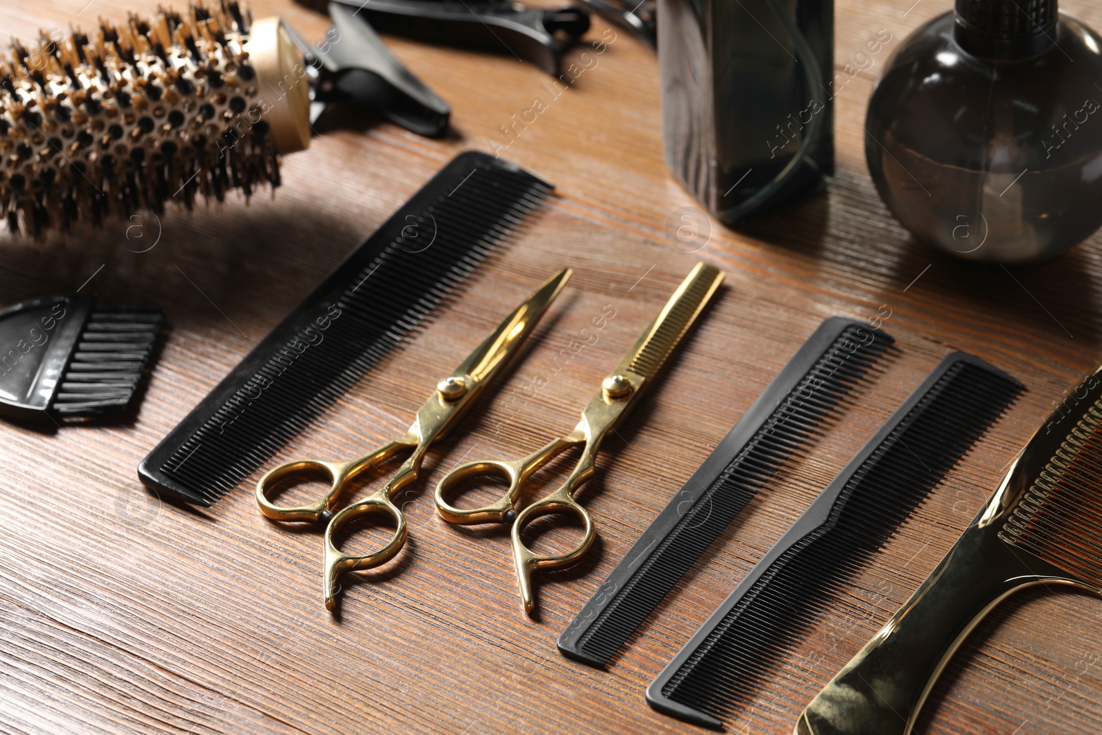 Photo of Hairdresser tools. Different scissors and combs on wooden table